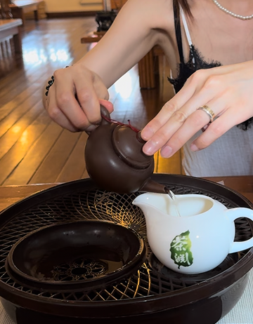 Pouring tea from a clay teapot